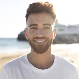 Image d'une jeune homme qui sourit à la plage